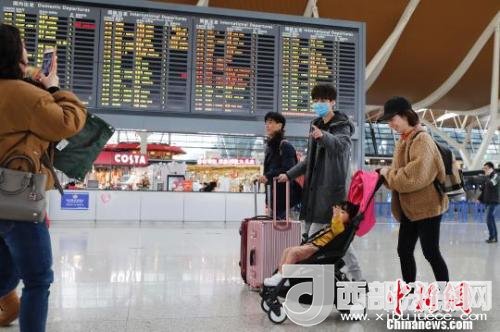 旅客帶著孩子前往辦票柜臺(tái)辦理登機(jī)手續(xù)?！∫罅⑶?攝