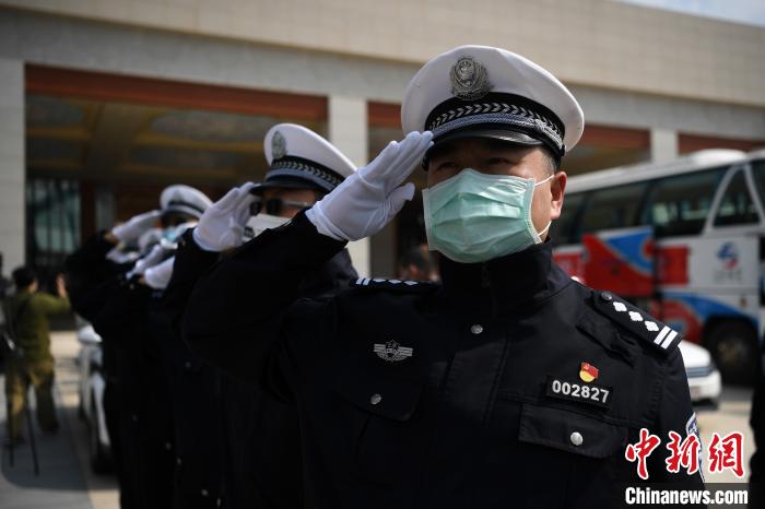 圖為交警們向醫(yī)療隊(duì)敬禮?！】灯?攝