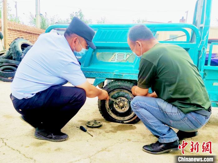 賽旦與民警共同維修三輪摩托車?！∫懒窘?攝