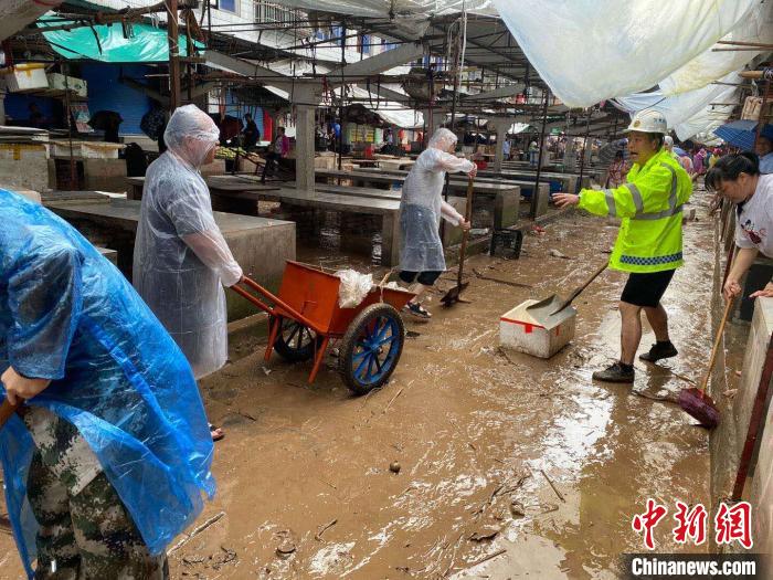 圖為7月26日，暴雨引發(fā)的洪水過境后，重慶萬州區(qū)分水鎮(zhèn)政府干部職工及志愿者清掃淤泥和垃圾?！　≈貞c萬州區(qū)委宣傳部供圖 攝