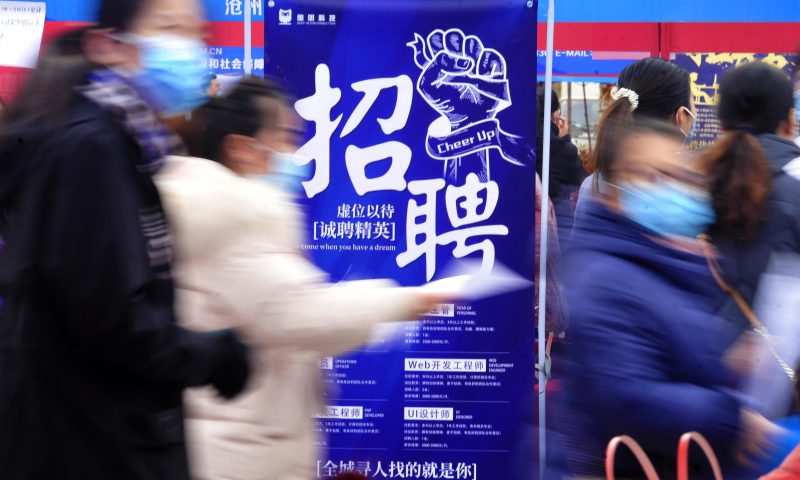 求職者從一家招聘企業(yè)的廣告牌前走過。新華社發(fā)（苑立偉 攝）