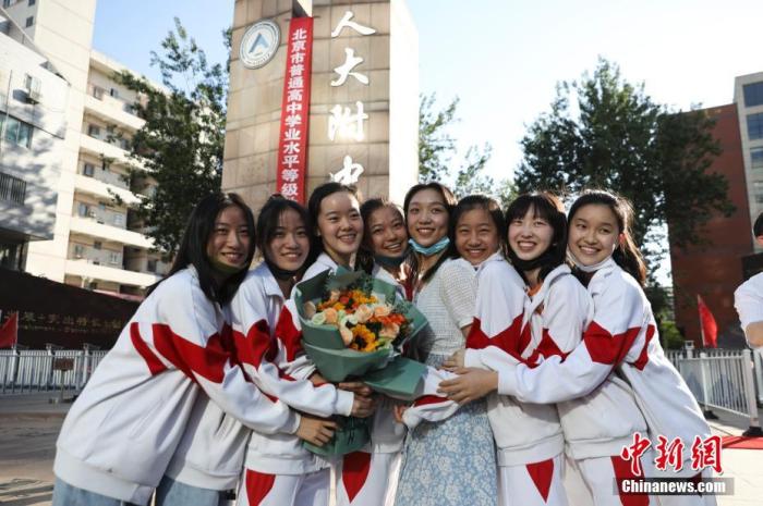 資料圖：6月10日，在北京人大附中高考考點(diǎn)外，考生們相擁拍照留念。當(dāng)日，北京市2021年高考結(jié)束?！?<a target='_blank'  data-cke-saved- ><p  align=